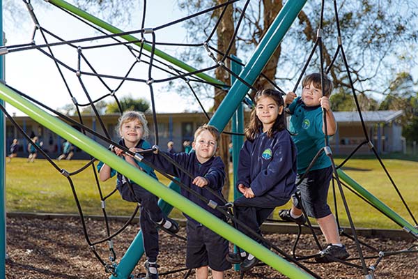 Group of Kindergarten students playing on the outdoor climbing equipment