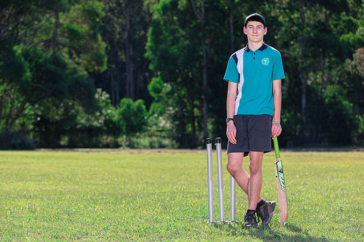 Student in sports uniform playing cricket