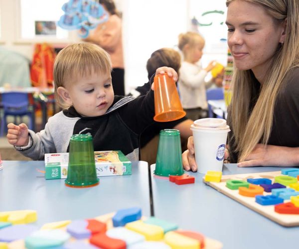 Mum enjoying coffee while child plays with activities
