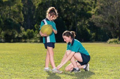 Friends helping to tie their shoe